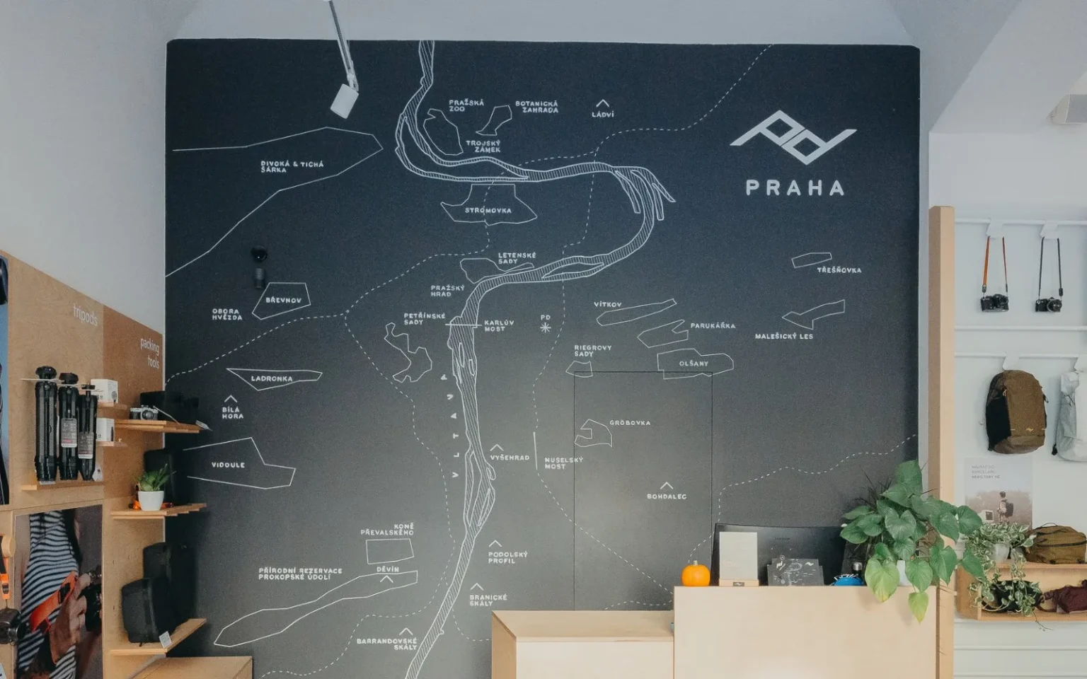 Mapa Prahy s logem Peak Design na stěně Peak Design Prague Store